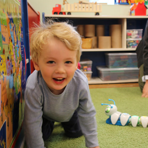 small toddler boy smiling playing with toys